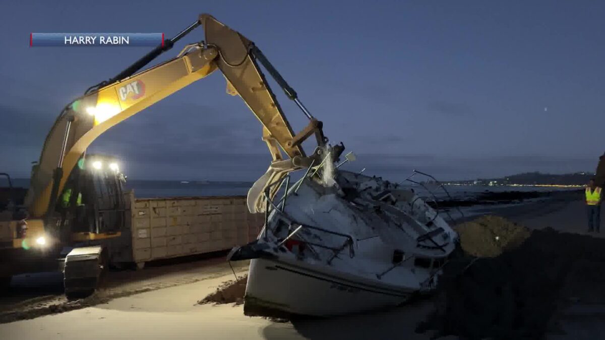 Cleanup of a crashed boat takes place at dawn on a Montecito beach