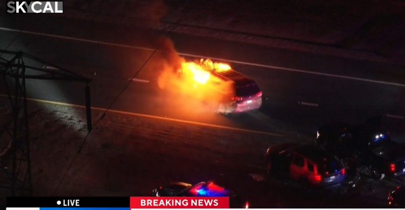 Flames engulf the minivan. Police redirected traffic away from the burning van until the fire department arrived to douse the flames.