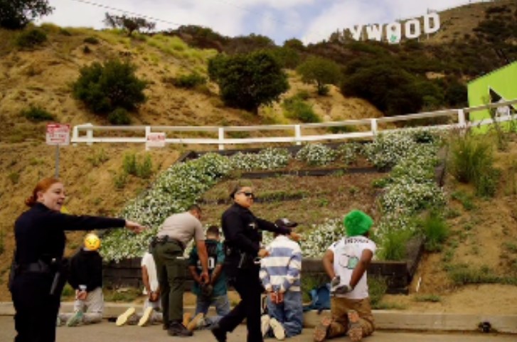 The suspects kneeling as LAPD officers placed them into custody over the weekend.
