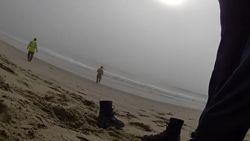 The deputies' body cameras captured them running into the ocean to save the paragliders.