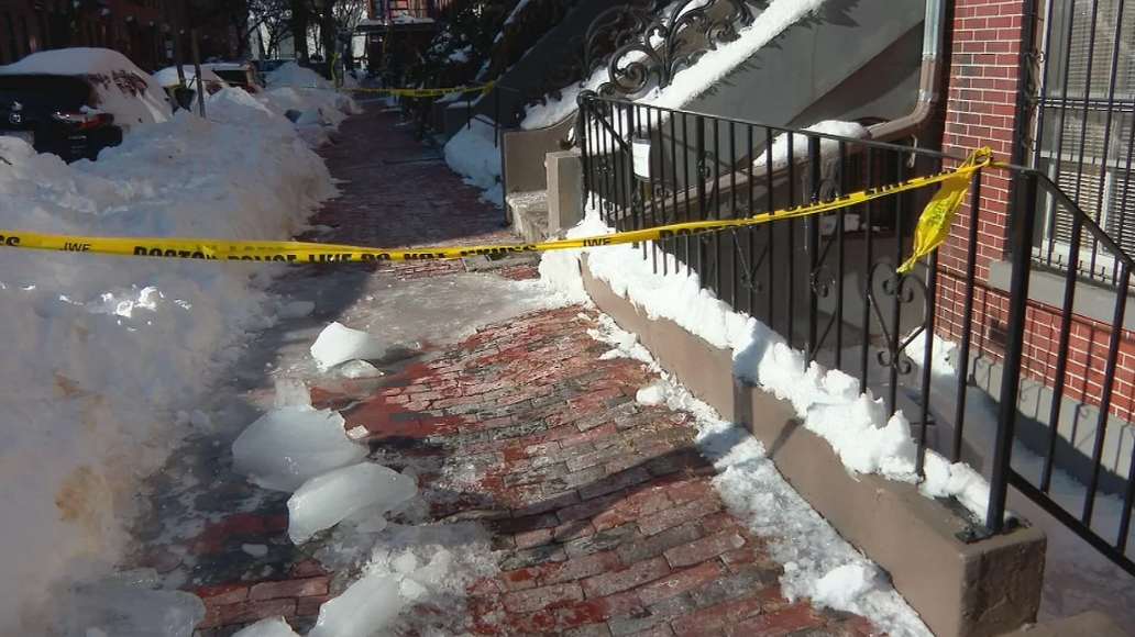 Caution tape across a sidewalk on Milford Street in Boston's South End after ice fell from a building.