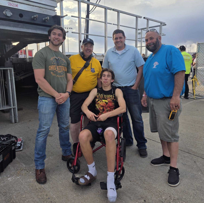 Frank (left) and Miles Engstrom (center) of Pretty Uncommon pose with members of the Nevada Fire Department after playing at Pizza Pie Looza on May 8.