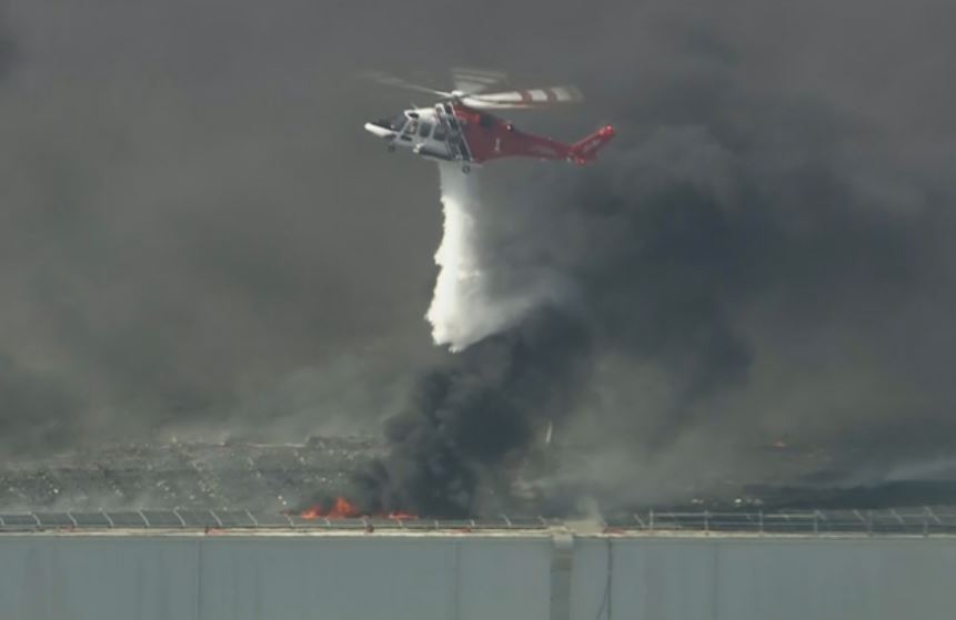 An LAFD helicopter dropping water on the burning Boyle Heights building on Wednesday