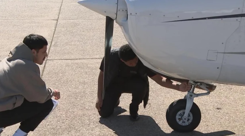 Jonathan Suarez (right) works on a plane with a fellow student.