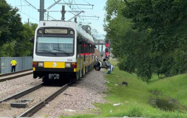 A collision between a car and a DART train in northeast Dallas on Sunday left one person dead and two others injured