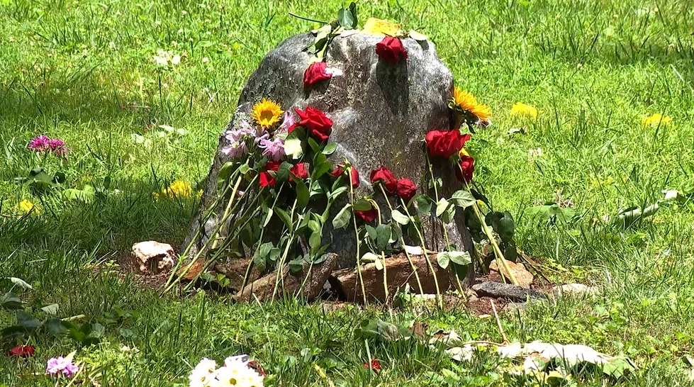 Flowers sit in front of the burned home of Wendy and Robert Peck