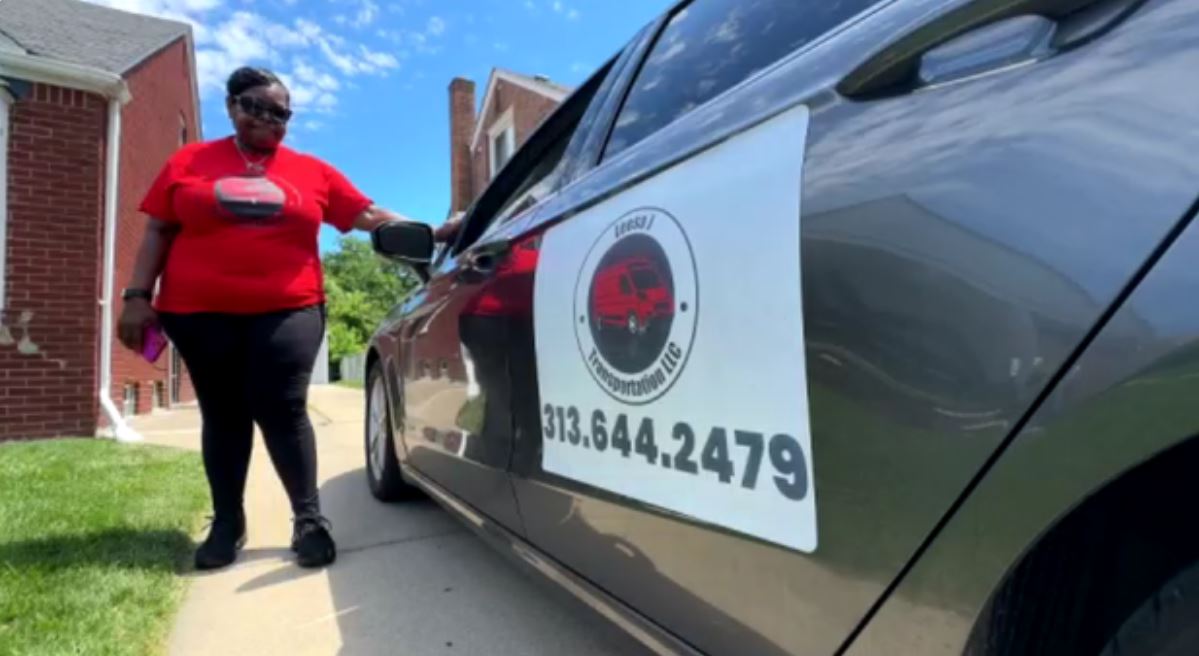 Lawanda Williams stands next to the car she uses for her nonemergency transport service