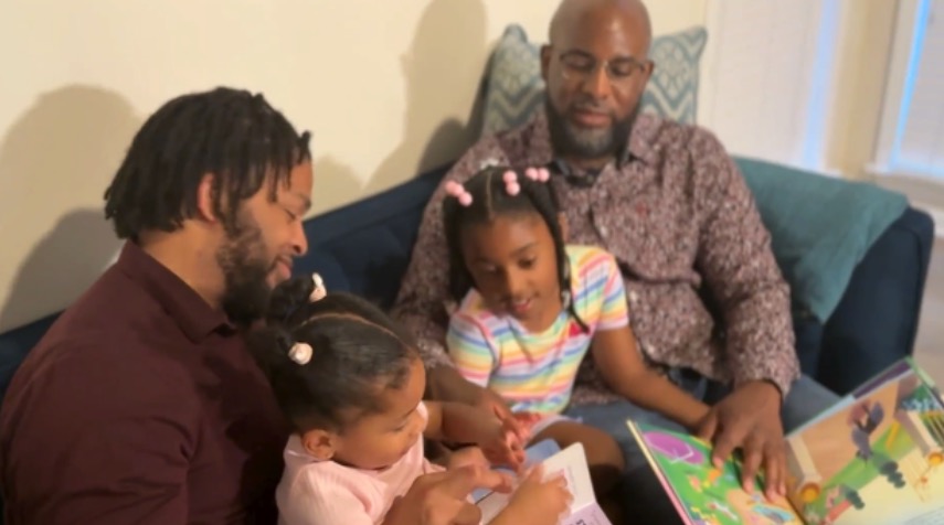 Dr. Algernon Cargill and Ronaldo Coxson read with their daughters Elle and Grace.