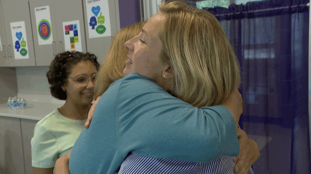 Social Studies teacher Hannah Bomback embraces Melissa Johnson