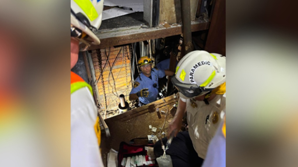 A man was rescued after he fell down an elevator shaft and was pinned at the bottom for hours