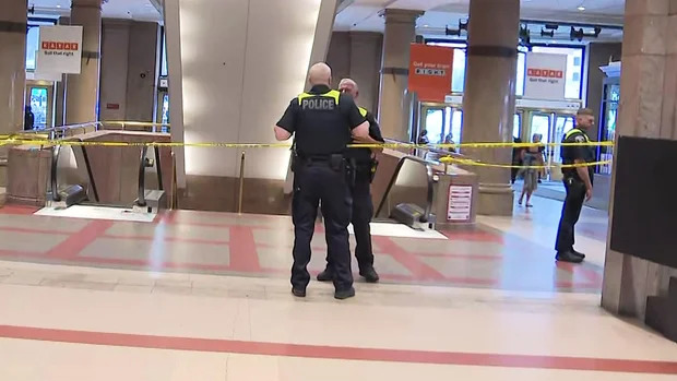 Crime scene tape around escalator in Boston's South Station after fatal stabbing.