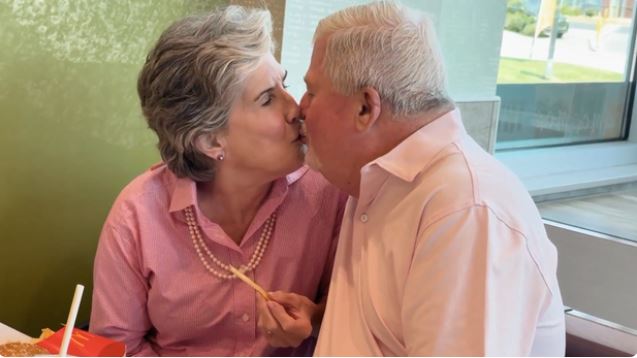 Mike and Susan Burks share a kiss at the McDonald's on Northside Parkway