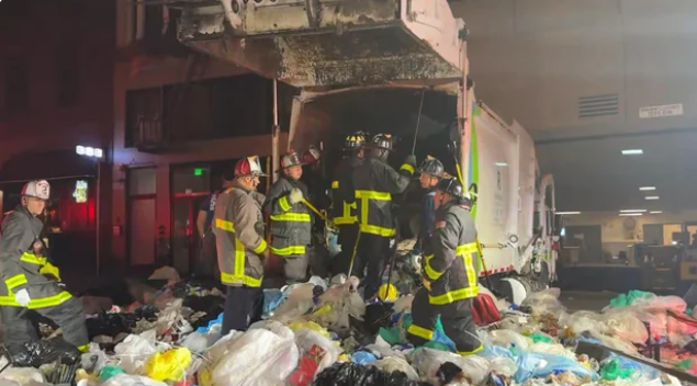 Firefighters rescue a person trapped inside a garbage truck on Mason Street near Eddy Street