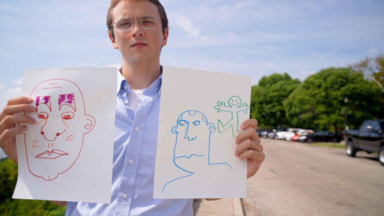 Spencer Lamb stands with two drawings at Eden Park. He made a short film