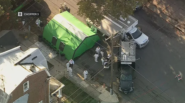 FBI and Philadelphia police investigators congregate next to an inflatable tent outside the Chew Avenue "house of horrors" on Monday