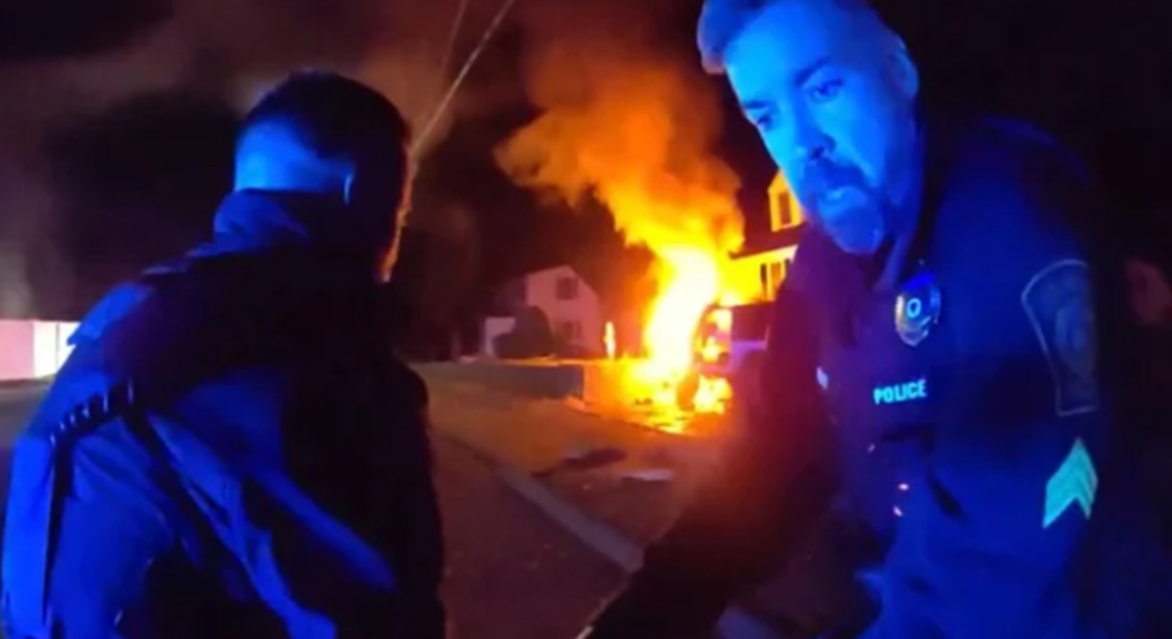 Holbrook police officers drag a driver to safety following a fiery crash.